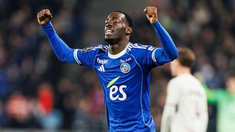 Rabby Nzingoula celebrates while wearing a blue Strasbourg shirt
