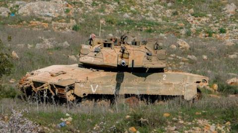 An Israeli military tank manoeuvres on grassy terrain near the southern Lebanese border town of Blida on 2 February 2025