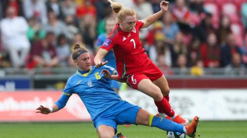 Daiana Semkiv vies for the ball with Wales' midfielder Ceri Holland