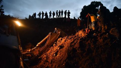 Firefighters and members of the army and Civil Defense look for survivors