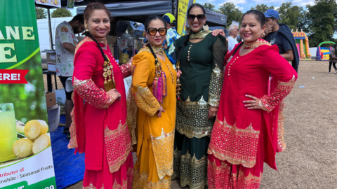 Four women at a South Asian Festival smiling into the camera