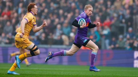 Josh Hodge of Exeter Chiefs goes over for a try beating George Hendy of Northampton Saints during the Prem Rugby Cup Semi Final at Sandy Park.