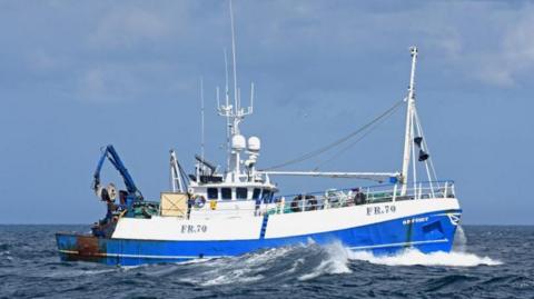 Odyssey FR70 fishing boat at sea, blue and white trawler, amid waves