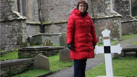 Janet Bradshaw by the grave of Leonie Demoulin at Laugharne