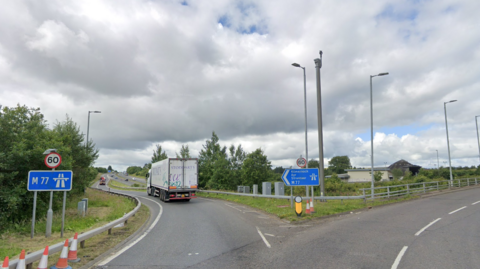 Junction five of the M77 showing signs to Kilmarnock, Ayr and Stranraer leading on to the motorway.