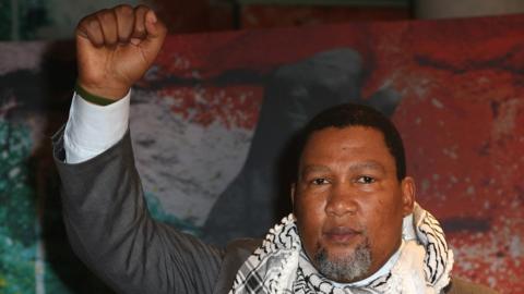 Zwelivelile Mandela raises his fist