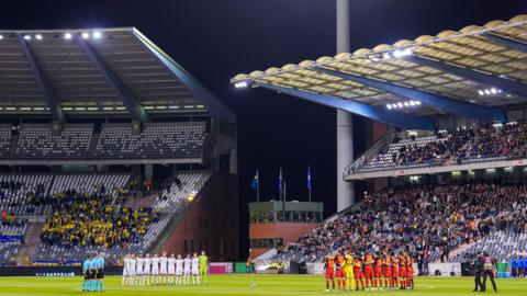 Belgium and Sweden players stand on the pitch