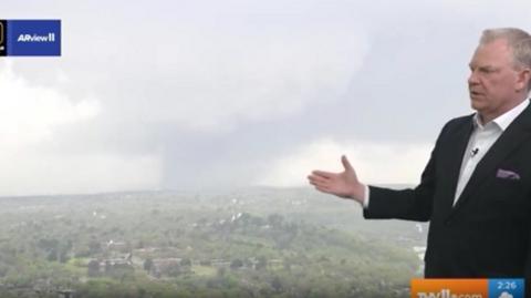 Weather presenter showing tornado