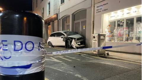 Wrecked car behind police tape