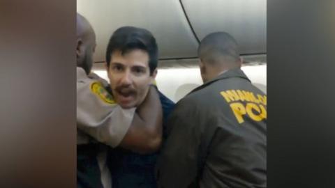 A man accused of groping a passenger refused to leave and wrestled officers who tried to remove him.