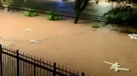 White crosses floating down a flooded road