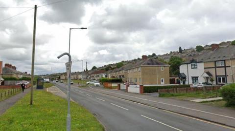 Google maps image of Gors Avenue, Townhill, in Swansea. Grass is visible on the left of the road, with terraced houses on both sides. 