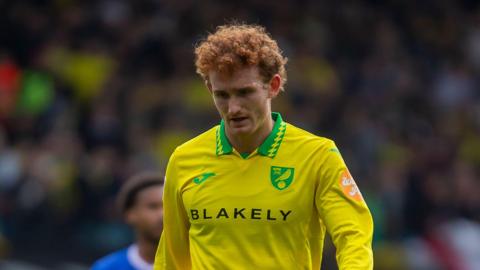 A photo of Josh Sargent looking down at the pitch while wearing a Norwich City home shirt