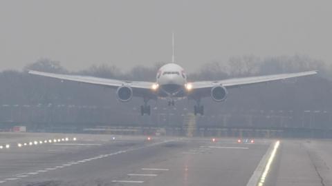 A plane lands in misty conditions from London Gatwick airport in Crawley, West Sussex. 