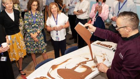 Visitors to a new research hub watching chocolate samples being prepared in one of the kitchens