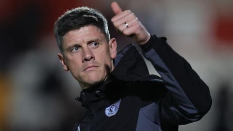 Stevenage manager Alex Revell gives a thumbs up signal