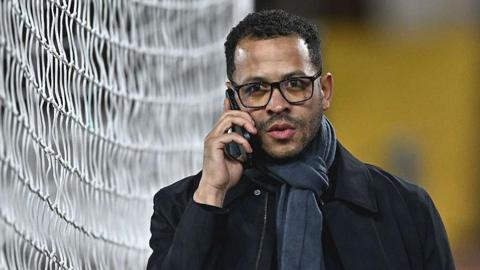 Liam Rosenior on the phone while walking next to one of the goals at Fulham