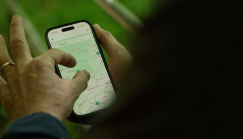 A man pinches a screenshot of a map on his phone