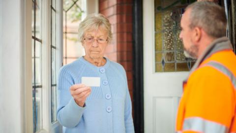 Elderly lady checking workman's credentials