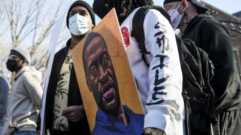 A man holds a portrait of George Floyd during a protest demonstration outside the Governors Mansion on March 6, 2021 in St. Paul, Minnesota.