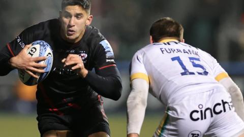 Lucio Cinti of Saracens takes on George Furbank of Northampton Saints