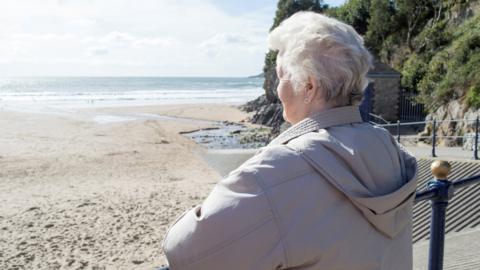 Older woman looking out to sea