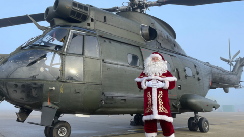 'Santa' stands in front of an RAF helicopter