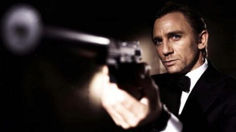 Daniel Craig as James Bond. He is seen wearing a tuxedo and pointing a gun off-screen.