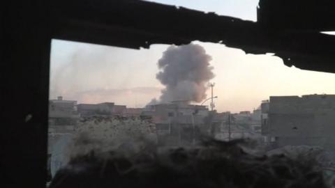 A plume of smoke rises over Mosul