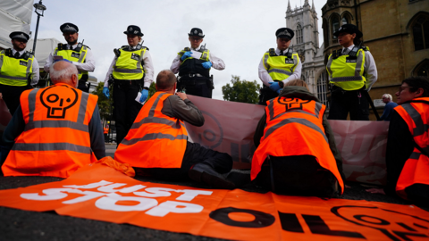 Just Stop Oil protesters facing police officers in London in October