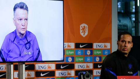 Louis van Gaal taking part in a news conference via a video link, with Virgil van Dijk there in person