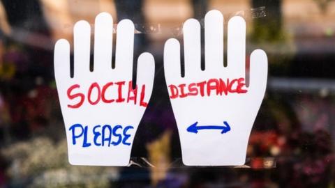 A sign made from handprints in New York urging social distancing