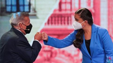 Peru"s presidential candidates Cesar Acuna of the Alianza Para el Progreso party and Veronica Mendoza of Juntos por el Peru party bump fists as they participate in a presidential candidates debate, in Lima, Peru March 29, 202