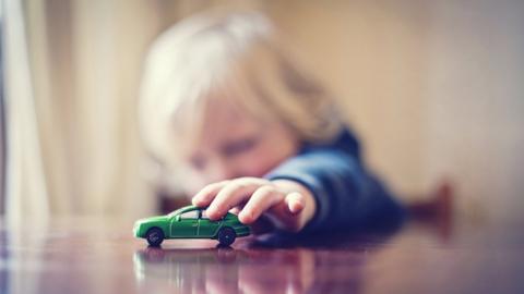 Child playing with toy car