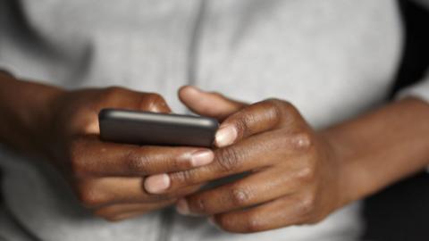 A stock image of a close up of a teenager using a mobile phone.