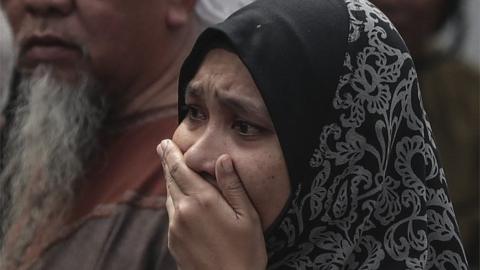 Relative of a boy who died cries outside the school