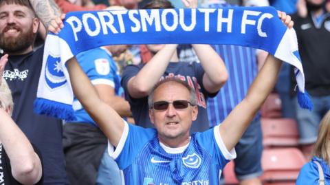 Portsmouth fan waves his scarf at Fratton Park.