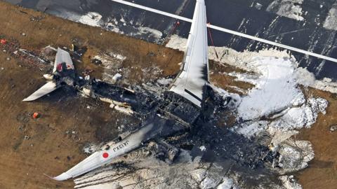 An aerial photo shows a burnt out Japan Airlines' (JAL) Airbus A350 plane after a collision with a Japan Coast Guard aircraft at Haneda International Airport in Tokyo, Japan January 3, 2024