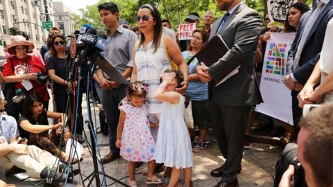 News conference with reporters and Sandra Chica, wife, and two daughters