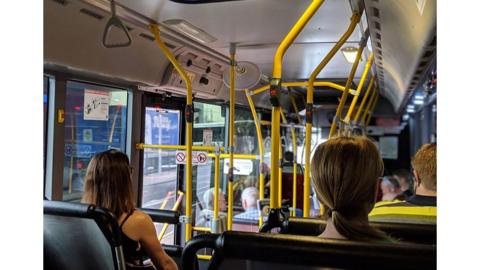 Three people sat on a bus