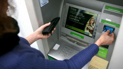 A woman uses an ATM machine
