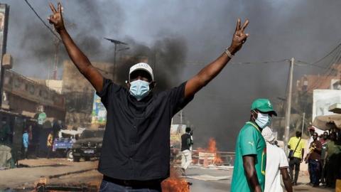 A Senegalese demonstrator reacts during clashes with riot police as they protest against the postponement of the Feb. 25 presidential election, in Dakar, Senegal February 4, 2024.