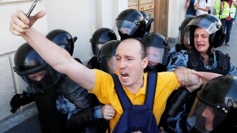 Russian riot police detain a protester