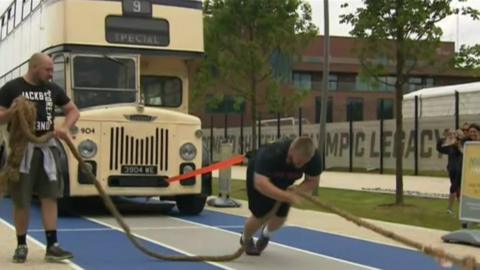 Man pulling double decker bus