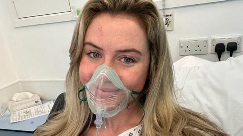 Sophie Richards in hospital wearing an oxygen mask