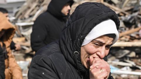 A woman grieves near a collapsed building in the Turkish city of Kahramanmaras (7 February 2023)