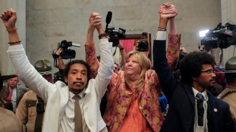 Justin Jones, Gloria Johnson and Justin Pearson raise their hands in the rotunda at the State Capitol in Nashville, Tennessee, U.S., April 6