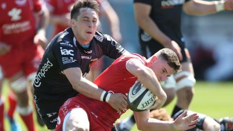 Dane Blacker of Scarlets beats Sam Davies of Dragons