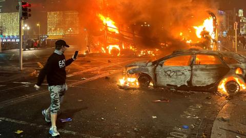 Flames rise from a car and a bus, set alight at the junction of Bachelors Walk and the O'Connell Bridge, in Dublin, Ireland, on 23 November 2023