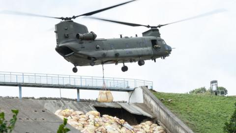 Helicopter laying sandbags